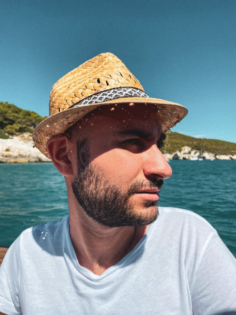 Michele wearing a summer hat in a seaside setting